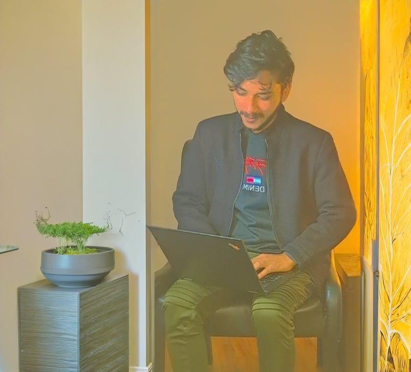 Abdul Rehman - Working on a laptop while sitting on a chair