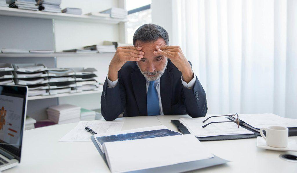 a stressed out lawyer looking at the paper chaos